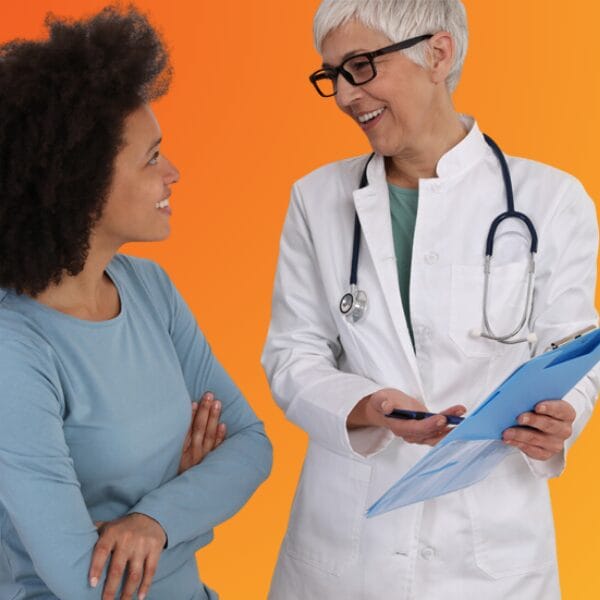 A woman doctor reviewing a document on a clipboard with a woman patient